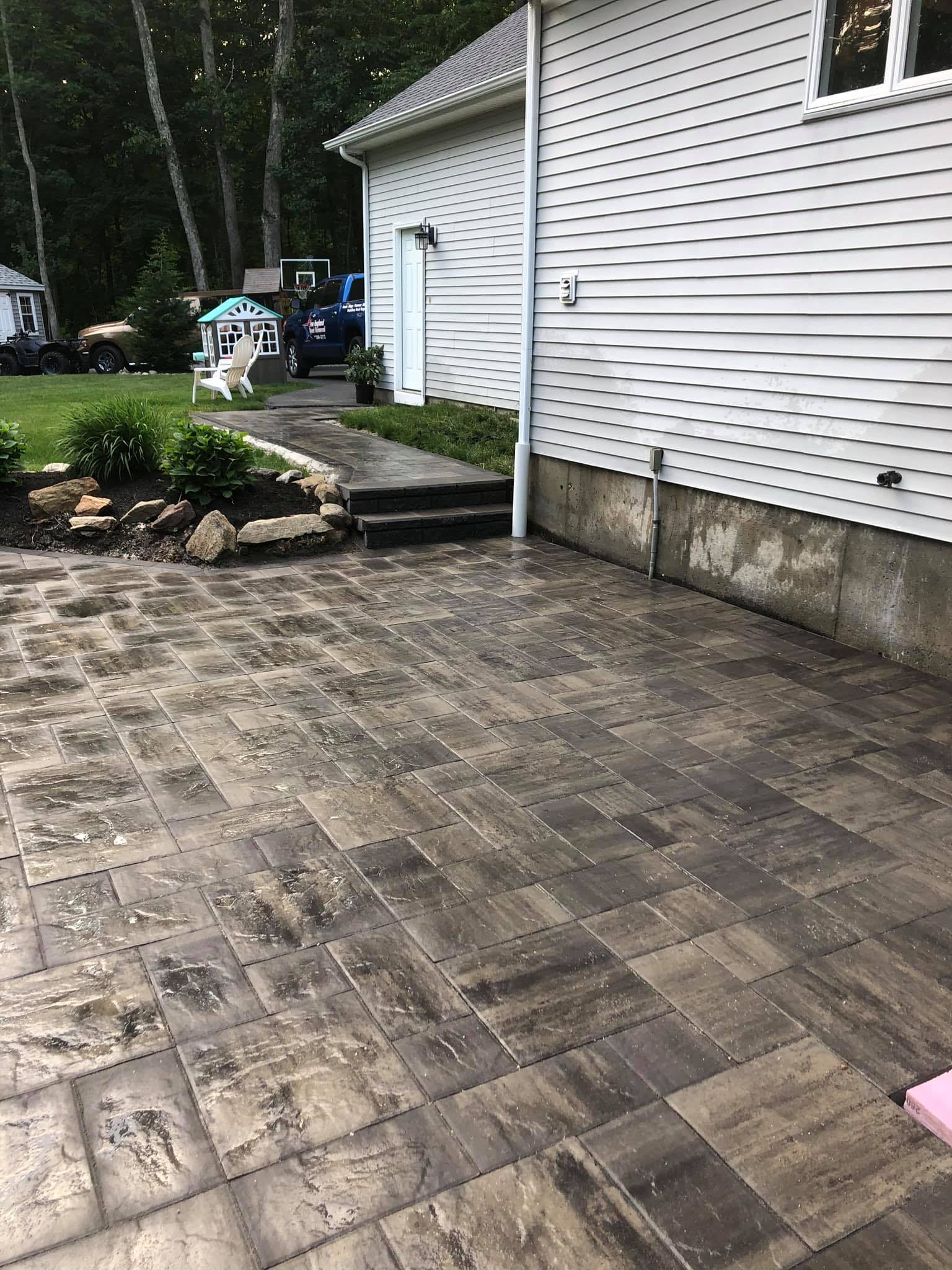 Custom stamped paver patio installed beside a Rhode Island home