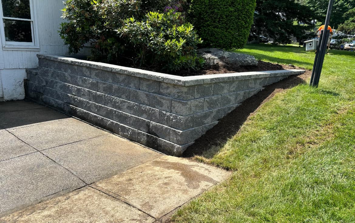 Block retaining wall along a planted slope